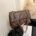 Brown quilted crossbody bag with gold chain strap and vintage bear emblem detail - Brown