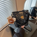 Black quilted bucket bag with gold lock and brown plush monster charm on side - With Plush Monster Charm / Black