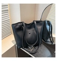 Detalle del bolso tote de cuero negro mate con bolsillo frontal con hebilla y textura elegante - Negro