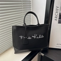 Bolso tote de lona negra con firma Frida Kahlo, ribete de cuero y etiqueta a juego - Negro