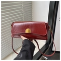 Dettaglio borsa a tracolla bordeaux vintage con texture pelle cerata e chiusura dorata - Rosso