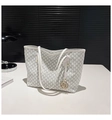 Dettaglio di una borsa tote bianca con motivo M e un ciondolo rotondo in metallo dorato - Bianco
