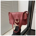 Close-up of dark red crocodile pattern handbag with gold U-shaped metal clasp detail - Red