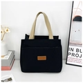 Dettaglio di una robusta borsa tote in tela nera con manici beige ed etichetta in pelle sport - Stile Etichetta in Pelle - Nero