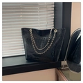 Dettaglio borsa tote nera a motivo coccodrillo con elegante tracolla a catena dorata - Nero