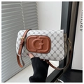 Detail showing the brown leather G-embossed logo and vintage monogram pattern on the handbag - White
