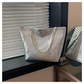 Macro della texture in pelle goffrata coccodrillo argento su borsa tote con catena metallica - Argento