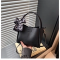 Close-up of black lychee grain leather bucket bag with fashion embossing and scarf - With Silk Scarf / Black