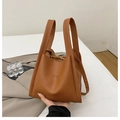 Dettaglio della borsa a secchiello in pelle marrone con trama litchi e goffratura moda - Marrone