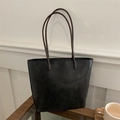 Retro black tote bag with brown straps shown in a minimalist aesthetic lifestyle setting - Black