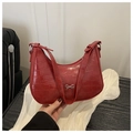 Detailed close-up of red hobo bag with crocodile embossed texture and silver metal bow - Red