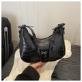 Close-up of black crocodile embossed faux leather with silver bow decoration detail - Black