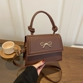 Dark brown faux leather crossbody bag with golden bow and knotted handle detail - Brown