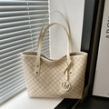 Premium beige Monogramm-Einkaufstasche mit M-Muster und Metallanhänger im sanften Licht - Weiß