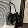 Modern black glossy drawstring bucket bag with silver bow detail and slim shoulder strap - Black