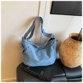Borsa a tracolla in denim lavato azzurro con tracolla regolabile su sfondo minimalista - Azzurro