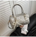 Close-up of silver snakeskin Boston bag with pearl bow charm and metal logo detail - With Pendant / Silver