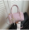 Detail of lavender Boston bag with snake skin texture and pearl bow charm - Purple