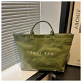 Olivgrüne Tragetasche mit glänzender Knitteroptik und weißem TOTE BAG Schriftzug - Grün