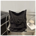 Detalle de bolso tote de lona negra con tres capas de volantes plisados y correa larga - Negro