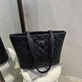 Chic black quilted tote bag with silver metal bow detail and elegant shoulder straps - Black