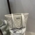 Chic quilted beige tote bag with a silver metal bow accent for women's daily commute - White