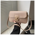 Detail of beige square shoulder bag featuring a modern gold geometric metal buckle closure - Khaki