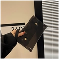 Detalle de un bolso sobre de PVC negro transparente con botones a presión dorados - Negro