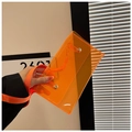 Detalle de un bolso de PVC transparente naranja vibrante con botones de presión dorados - Naranja