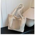 Detail of woven straw tote bag with faux leather patch and soft rope handles - White