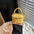 Gelbe Mini-Box-Tasche aus gestepptem Leder mit Tragegriff und Goldkette in Hand - Gelb