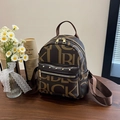 Minimochila marrón con estampado de letras y remaches dorados en mesa de madera - Marrón