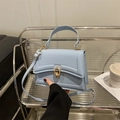 Sky blue textured leather crossbody bag with a gold metal ring clasp and top handle - Blue
