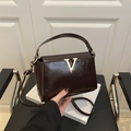 Elegante bolso bandolera marrón oscuro en ecopiel con adorno en V dorado y asa - Marrón