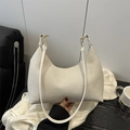 Weiße gewebte Hobo-Schultertasche aus Strick mit schmalem Riemen in der Hand - Weiß
