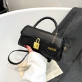 Retro black crossbody bag with gold buckle and a round fashion tag for 2025 summer look - Black