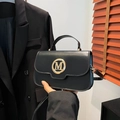Matte black crossbody bag with gold M-logo buckle and top handle for women - Black