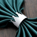 Elegant white crown paper napkin ring on green satin fabric for festive party table decor - White