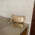 Golden crescent shoulder bag with lychee texture and braided strap details - Gold