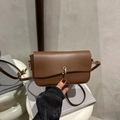 Bolso bandolera de cuero marrón con un elegante cierre circular de metal dorado - Marrón
