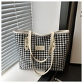 Dettaglio della borsa tote pied-de-poule con patch logo e tracolla color crema - Houndstooth