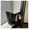 Dettaglio della borsa tote trapuntata con ricami e sciarpa decorativa elegante - Nero