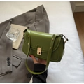 Detailansicht der grasgrünen matten Ledertasche mit Goldschloss und Nietendetails - Grün