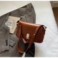 Detailansicht der braunen Vintage-Tasche mit goldenem Drehverschluss und Nietengurt - Braun