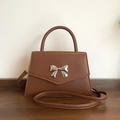 Brown faux leather crossbody bag with silver bow buckle and top handle feature - Brown
