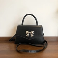 Elegant black crossbody bag featuring a silver metal bow accent and smooth matte finish - Black