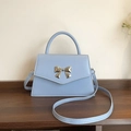 Elegant light blue faux leather handbag with a stylish golden butterfly bow clasp - Blue