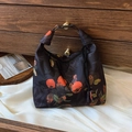 Vintage black silk bag featuring orange persimmon patterns and elegant black tassels - Persimmon