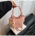 Pink leather bucket bag with plush bear charm and woven tassel detail for women - With Pendant / Pink