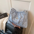 Sac fourre-tout matelassé bleu clair avec chaîne argentée et détails d'étoiles en main - Bleu